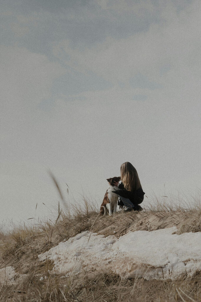 Hundeurlaub auf Borkum mit der Hundeschule Holt. Ein Hund bei seiner Besitzerin am Strand.